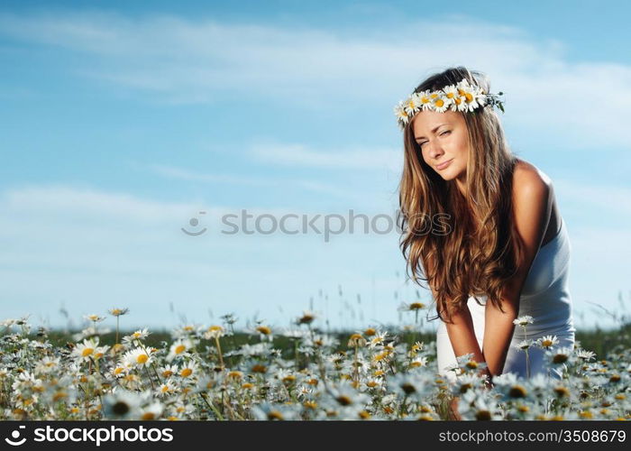 beautiful girl in dress on the daisy flowers field