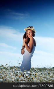 beautiful girl in dress on the daisy flowers field