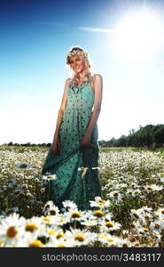 beautiful girl in dress on the sunny daisy flowers field