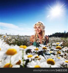 beautiful girl in dress on the sunny daisy flowers field