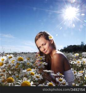beautiful girl in dress on the sunny daisy flowers field