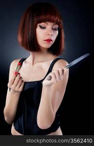 Beautiful girl in red hair wig putting on make up - reflects on table knife