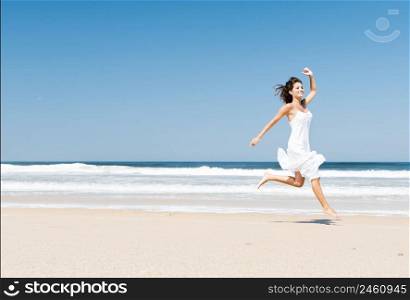 Beautiful girl in the beach enjoying the summer and jumping