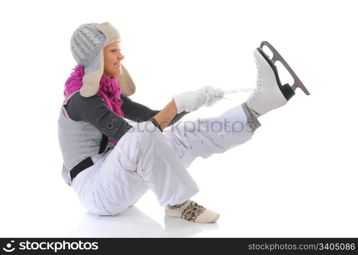 Beautiful girl in winter clothes puts on skates. Isolated on white background