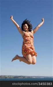 Beautiful girl jumping a over sky background