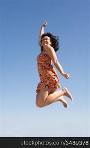 Beautiful girl jumping a over sky background