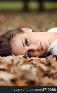 beautiful girl lies on the earth, oak leaves