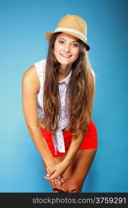 beautiful girl long hair in summer clothes and hat. Studio shot on blue background