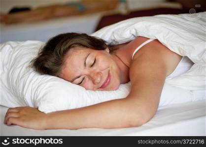 beautiful girl luxuriating in bed at dawn