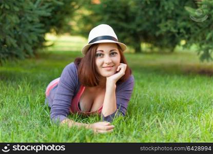 Beautiful girl lying in the green grass.