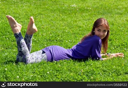 beautiful girl lying on green grass
