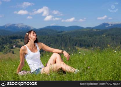 Beautiful girl lying on green grass field