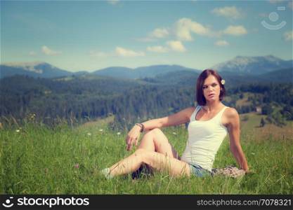 Beautiful girl lying on green grass field