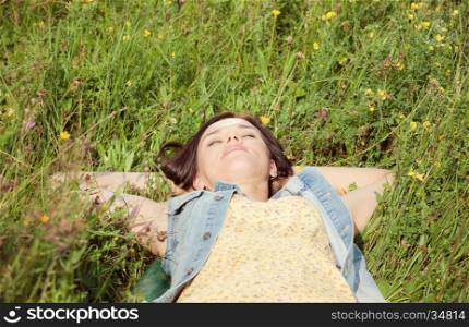 Beautiful girl lying on the summer meadow