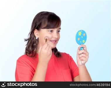 Beautiful girl makeup in front of a mirror isolated on blue background