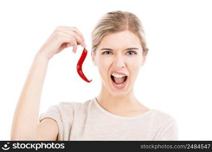 Beautiful girl making a silly face and holding a red chilli pepper, isolated over a white background