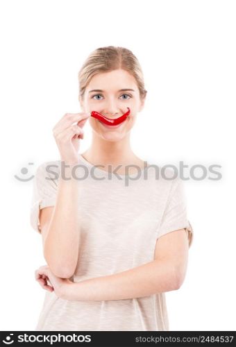 Beautiful girl making a smile with a red chilli pepper in front of the mouth, isolated over white background