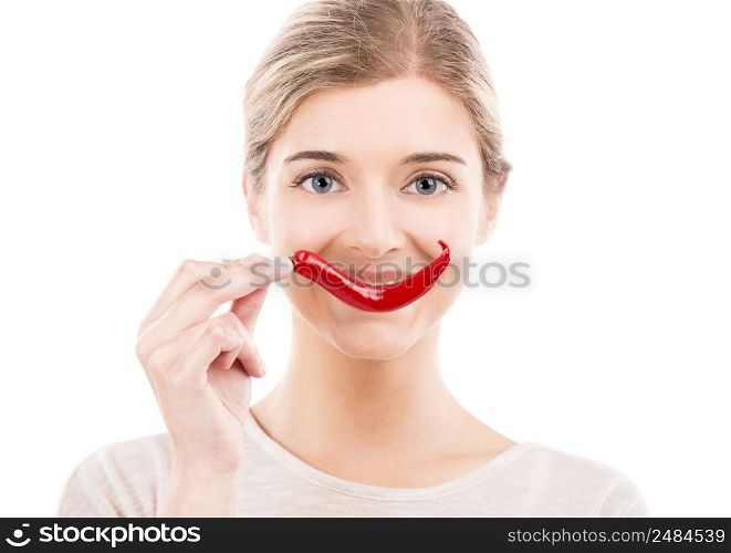 Beautiful girl making a smile with a red chilli pepper in front of the mouth, isolated over white background