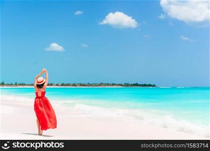 Beautiful girl on the beach in shallow water from above view. Happy girl at beach having a lot of fun in shallow water