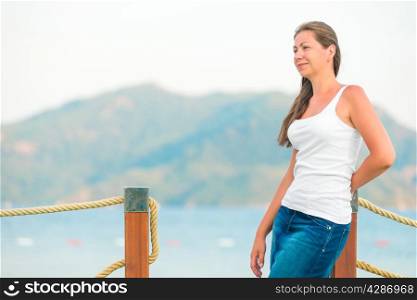 beautiful girl on the pier looks attentively aside
