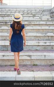 Beautiful girl on the steps in a blue dress and hat.. Beautiful girl on the steps in a blue dress and hat