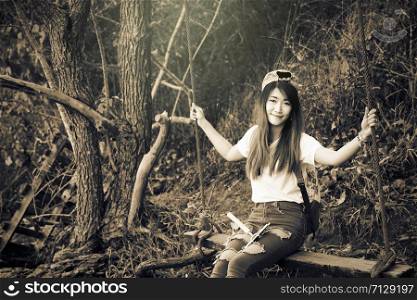 Beautiful girl on the swing in the forest color image, vintage style
