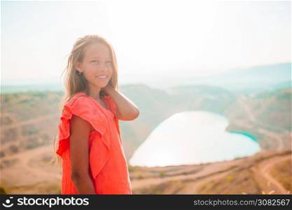 Beautiful girl on vacation near the lake like heart. Famous heart-shaped lake in Crimea. Little girl near the lake at the day time with amazing nature on background