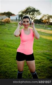 Beautiful girl outdoors enjoying nature in clothes for running with headphones