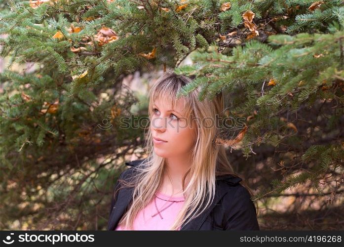 Beautiful girl portrait at autumn coniferous forest