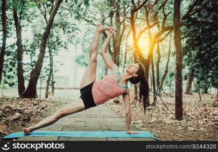 Beautiful girl practicing yoga power yoga at sunset. Young woman doing power yoga outdoors