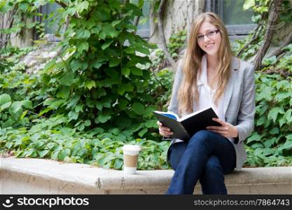 Beautiful girl reading a book outside