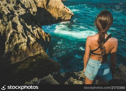 Beautiful girl standing on the edge of a cliff near the ocean, back view. Broken beach is beautiful rock coastline in Nusa Penida, Indonesia. Lifestyle concept. Travel Background. Nature landscape.. angels billabong, nusa penida, woman