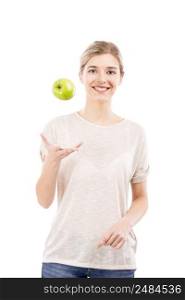 Beautiful girl throwing a green apple into the air, over a white background