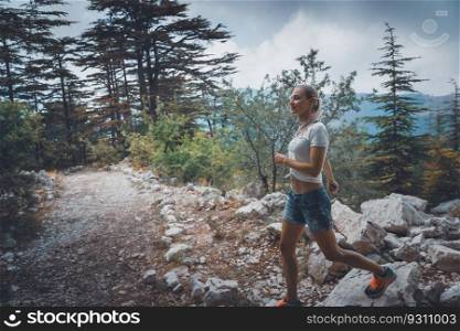 Beautiful girl walking in the mountains. Listening silence and enjoying peace of wild nature. Breezing a fresh air. a fresh air. Healthy lifestyle.. Active girl walking in the mountains
