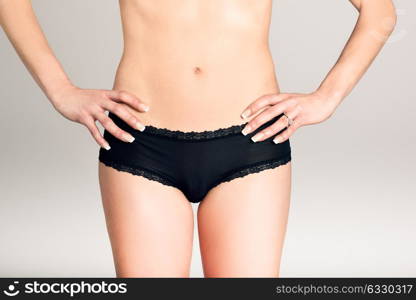 Beautiful girl wearing black panties on white background. Front view