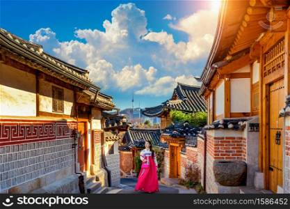 Beautiful girl wearing Korean traditional hanbok at Bukchon Hanok Village. Traditional Korean style architecture in Seoul,Korea.