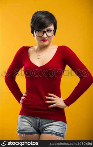 Beautiful girl wearing nerd glasses, aganist a yellow background