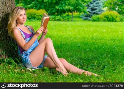 beautiful girl with a thick book in nature