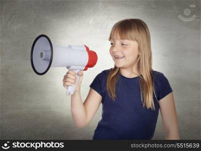 Beautiful girl with blond hair shouting on megaphone and a gray background