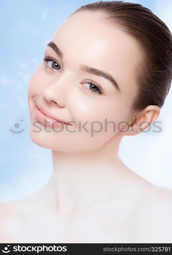 Beautiful girl with cute smile natural makeup spa skin care portrait on blue bokeh background with shiny glitter stars on neck