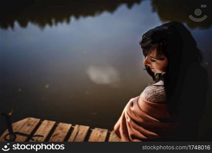 Beautiful girl with long brunette hair sitting on the bridge. nature.. Beautiful girl with long brunette hair sitting on the bridge. nature
