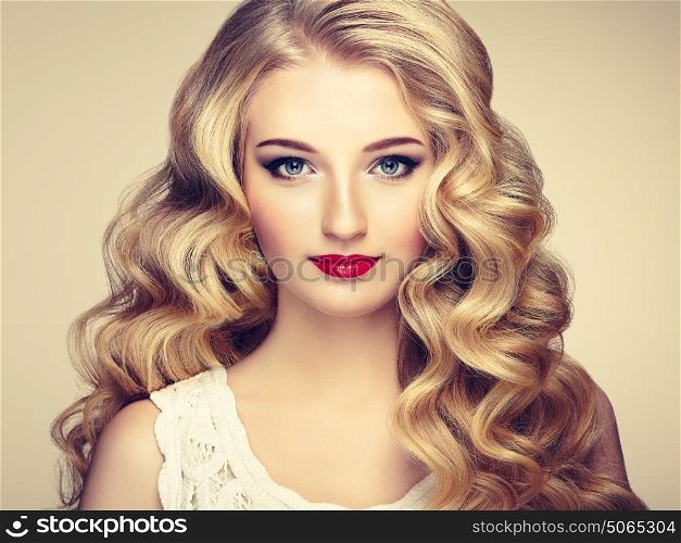 Beautiful girl with long wavy and shiny hair . Blonde woman with curly hairstyle. Perfect make-up. Fashion photo