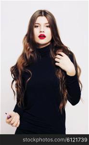 Beautiful girl with long wavy healthy hair. Brunette with curly hairstyle, and professional makeup, red lips.