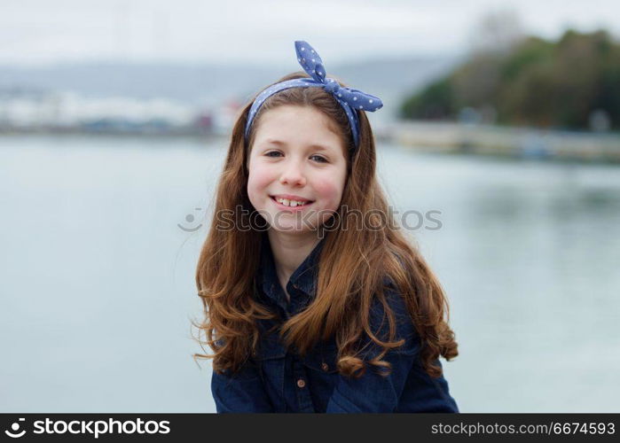 Beautiful girl with ten years old enjoying of a beautiful day. Beautiful girl with ten years old wearing a blue hair scarf enjoying of a beautiful day