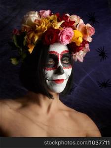 beautiful girl with traditional mexican death mask. Calavera Catrina. Sugar skull makeup. girl dressed in a wreath of roses on a background of white web