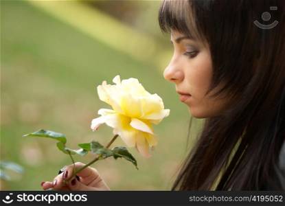 Beautiful girl with yellow rose, soft background