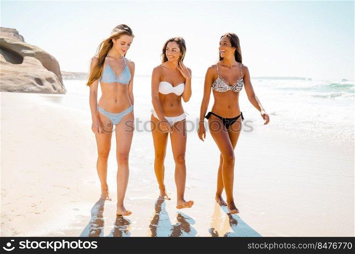 Beautiful girls enjoying the summer giving a walk on the beach 