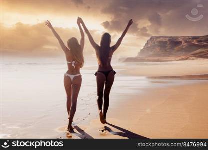 Beautiful girls in bikin walking on the beach