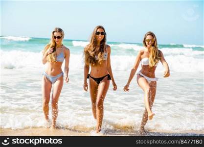 Beautiful girls in the beach having fun on the water