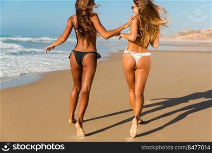 Beautiful girls running and having fun on the beach